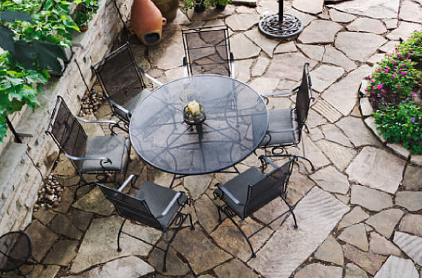 Round glass patio table on stoned patio