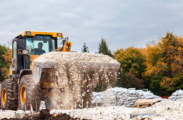 Moving stone aggregate piles with heavy machinery