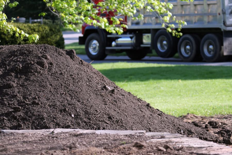 Large pile of topsoil in front of residential home