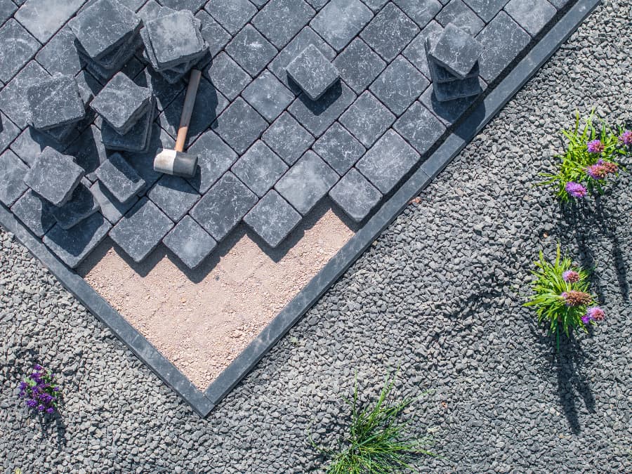 Creating patio with gray stones and mallet