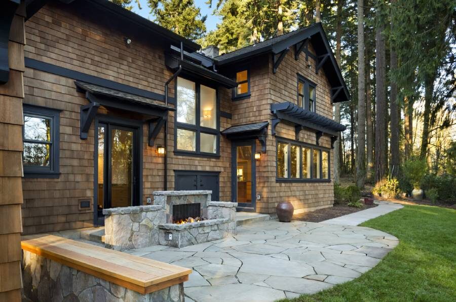 Beautiful stone outdoor fireplace behind home in the woods