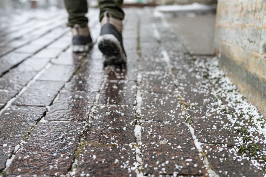 Pedestrian walking on cleared walkway during winter time